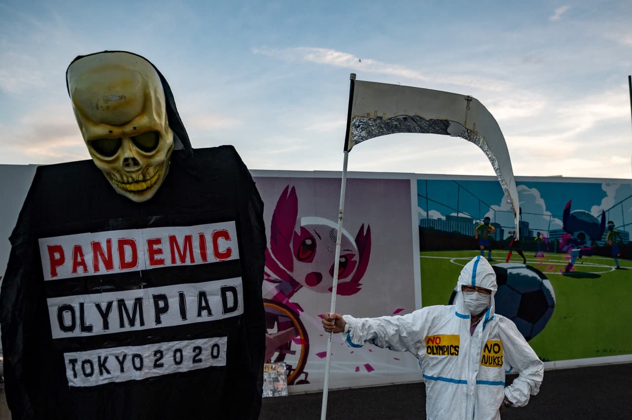 Algunos pequeños grupos de activistas contra las olimpiadas han marchado hacia la sede del comité organizador de los juegos en la capital japonesa, como el de la fotografía, tomada el 16 de julio. 
<br>
<br>Las estrictas medidas contra la propagación del covid-19 mantiene a muy pocas personas en las calles.