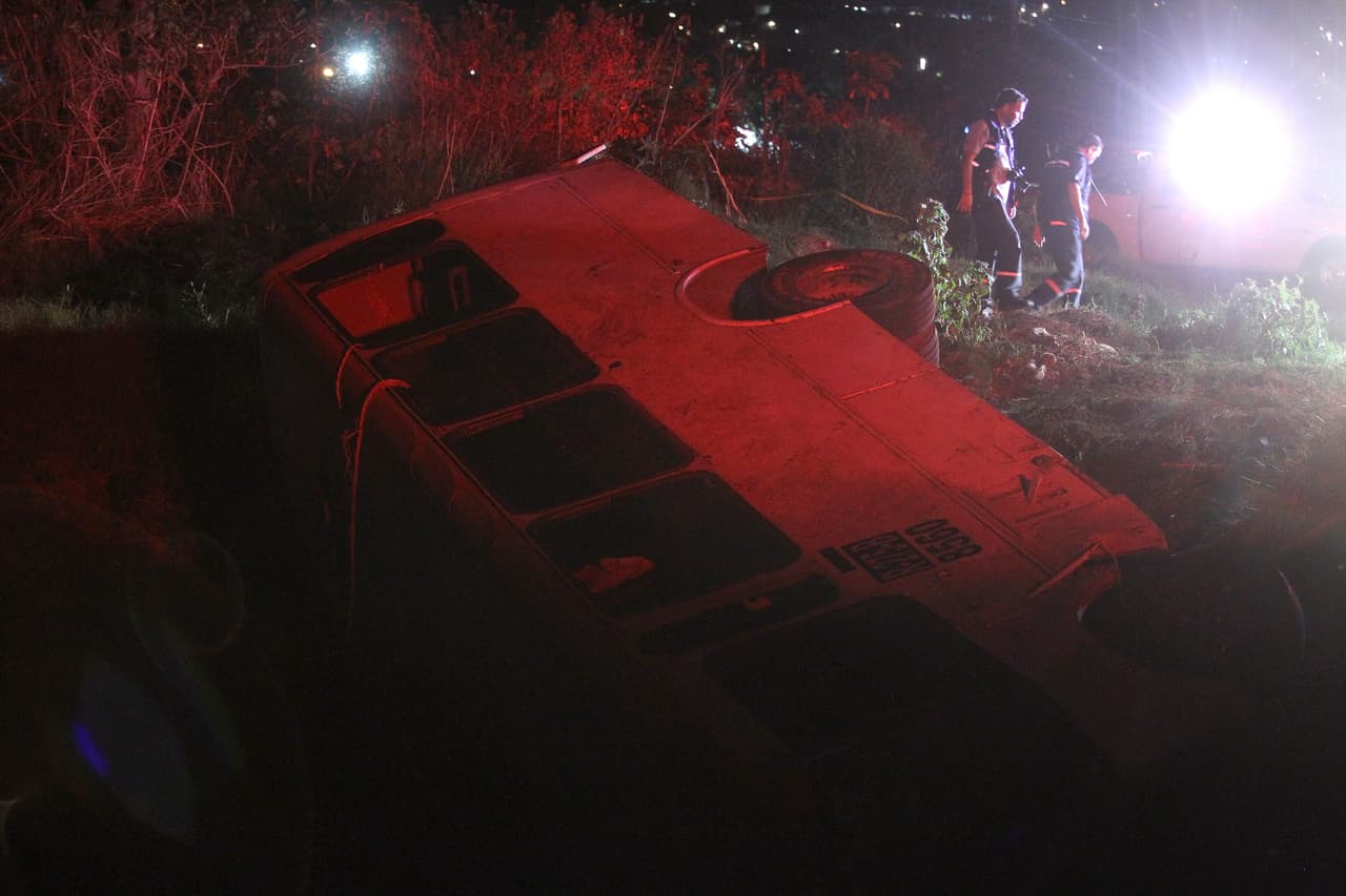 Un grupo de paramédicos y policías en la escena donde un autobús volcó dejando siete muertos y 28 heridos.