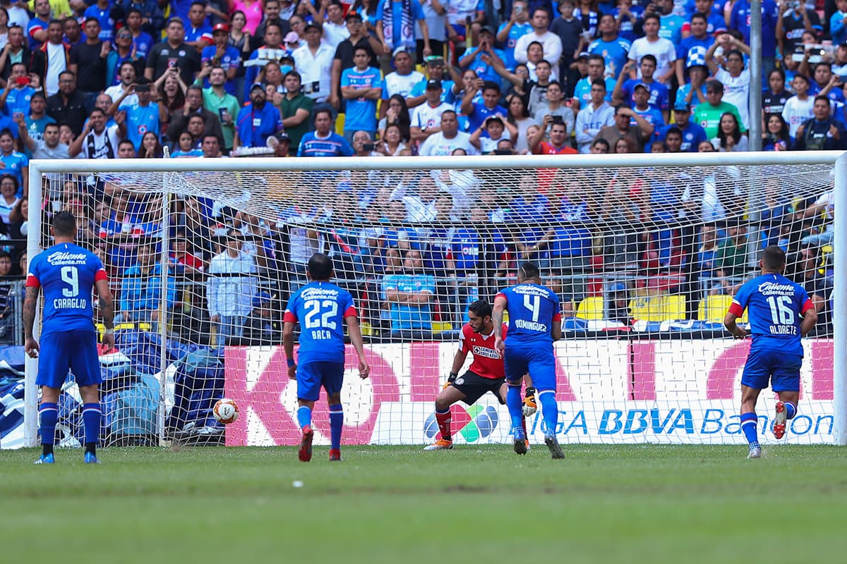 El arquero José Jesús Corona (centro) recibió su tercer gol del Apertura 2018, un tiro penal del mediocampista chileno Bryan Carrasco.
