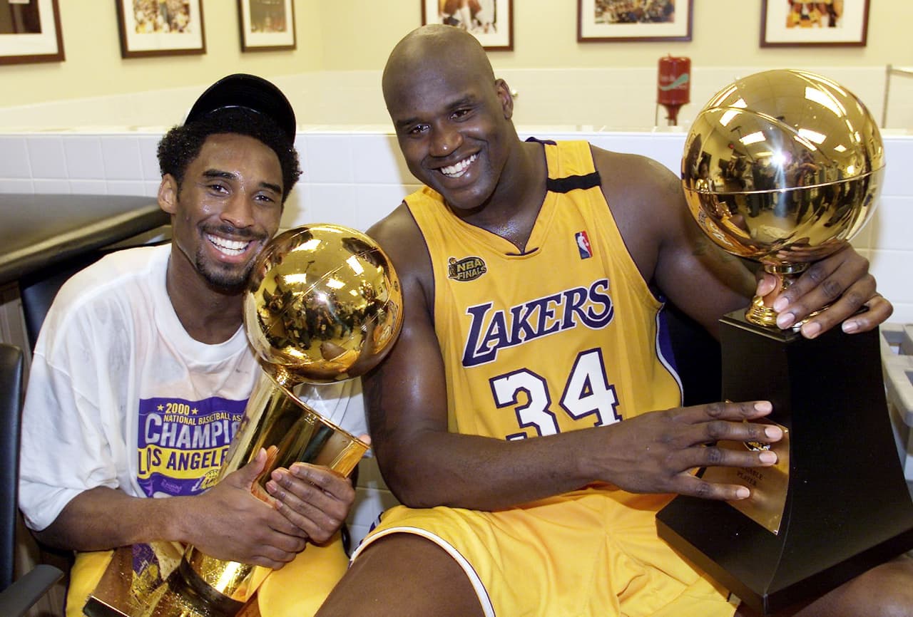 Kobe levanta el trofeo Larry O'Brian y Shaquille O'Neal, el MVP de la NBA en 2000.