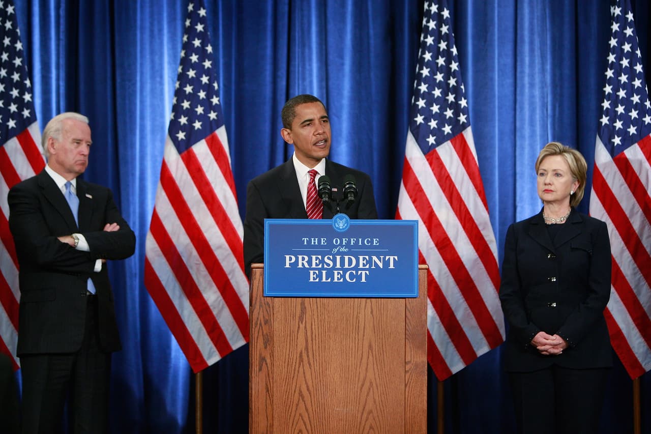 El vicepresidente Joe Biden, izq, observa mientras Barack Obama presenta a miembros de su Equipo de Seguridad Nacional, incluyendo a la entonces senadora Hillary Clinton como Secretaria de Estado, en diciembre 1, 2008, Chicago, Illinois.
