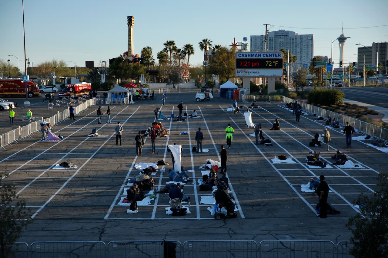 La gente se prepara para dormir en áreas marcadas con cajas pintadas en el suelo de un estacionamiento en un campamento improvisado para personas sin hogar el lunes 30 de marzo de 2020 en Las Vegas.