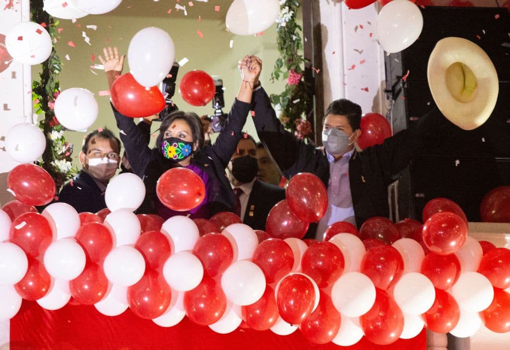 Pedro Castillo, junto con su compañera en la boleta electoral, Dina Boluarte, saludan a sus partidarios el 23 de julio de 2021.