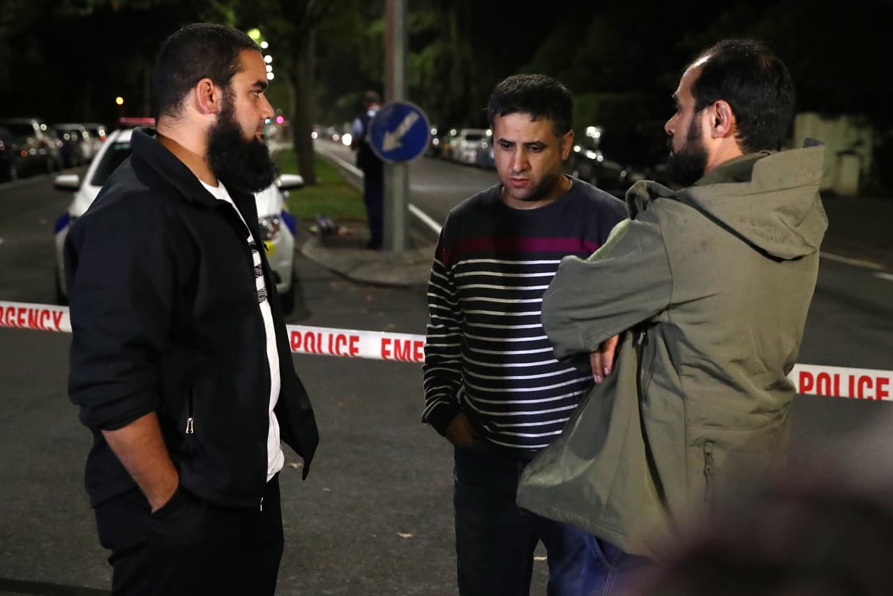 La policía afirmó además que ya no buscaba a más sospechosos. Las dos mezquitas atacadas eran la de de Masjid al Noor, en el centro de Christchurch, y otra en Linwood, en las afueras. Ambas estaban repletas el viernes para la sesión vespertina de oraciones cuando se registraron los primeros disparos.
<br>
<br>Ahmed Al-Mahmoud, al centro, uno de los sobrevivientes del tiroteo, espera en las afueras de la mezquita Al Noor, en Nueva Zelanda.