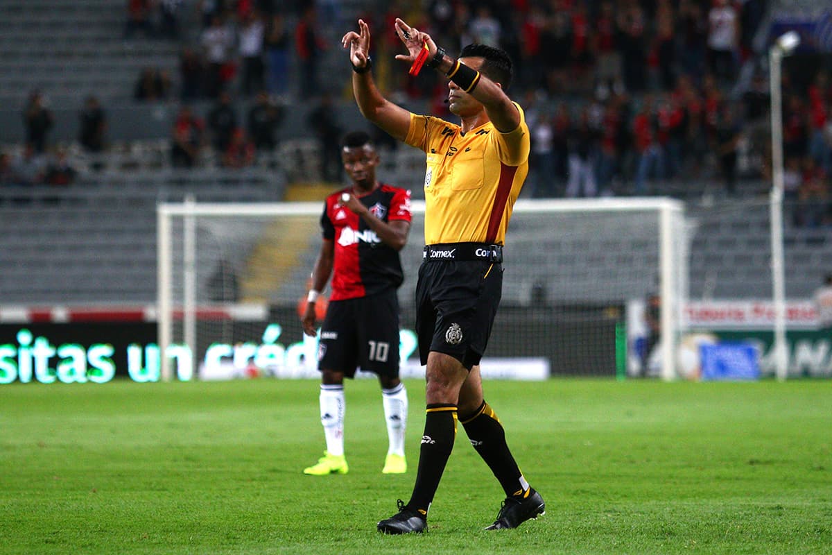 El árbitro Adonai Acevedo haciendo la seña de la revisión de una jugada por el VAR en el juego entre Atlas y Veracruz por la jornada 13 del Apertura 2018.