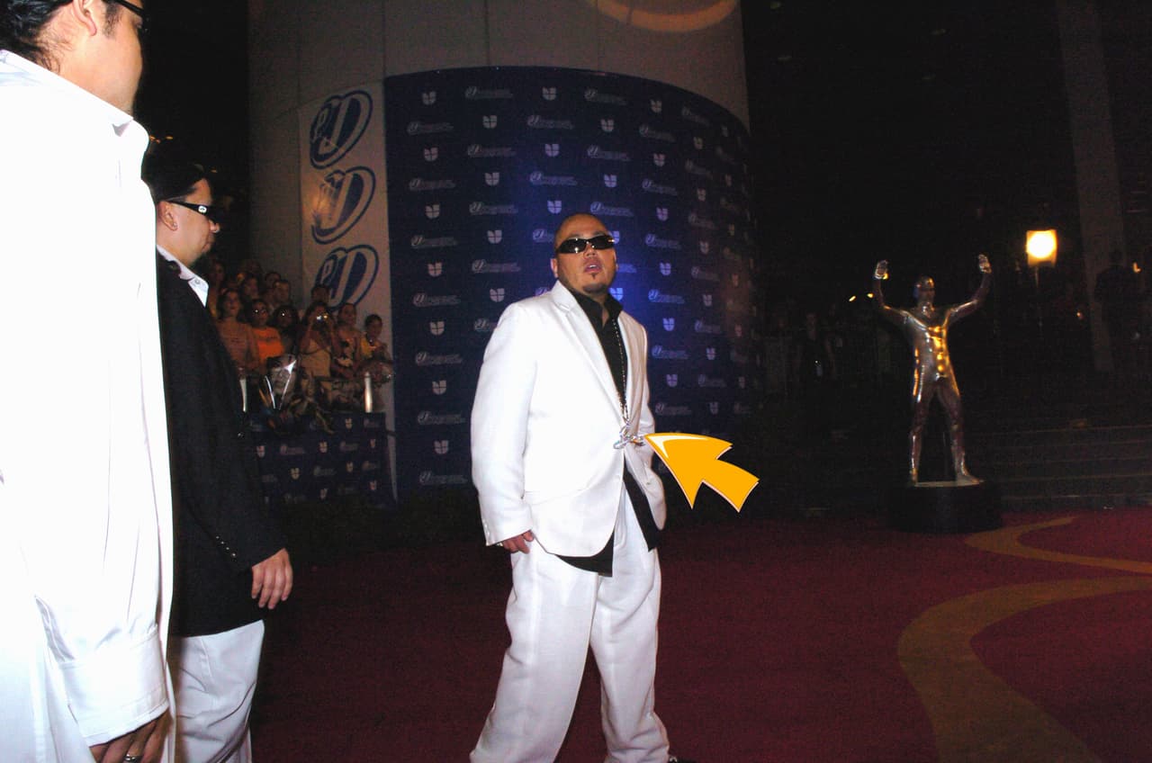 AB Quintanilla muy elegante con un traje blanco, camisa negra, pero eso sí, mostrando el 'bling bling'.