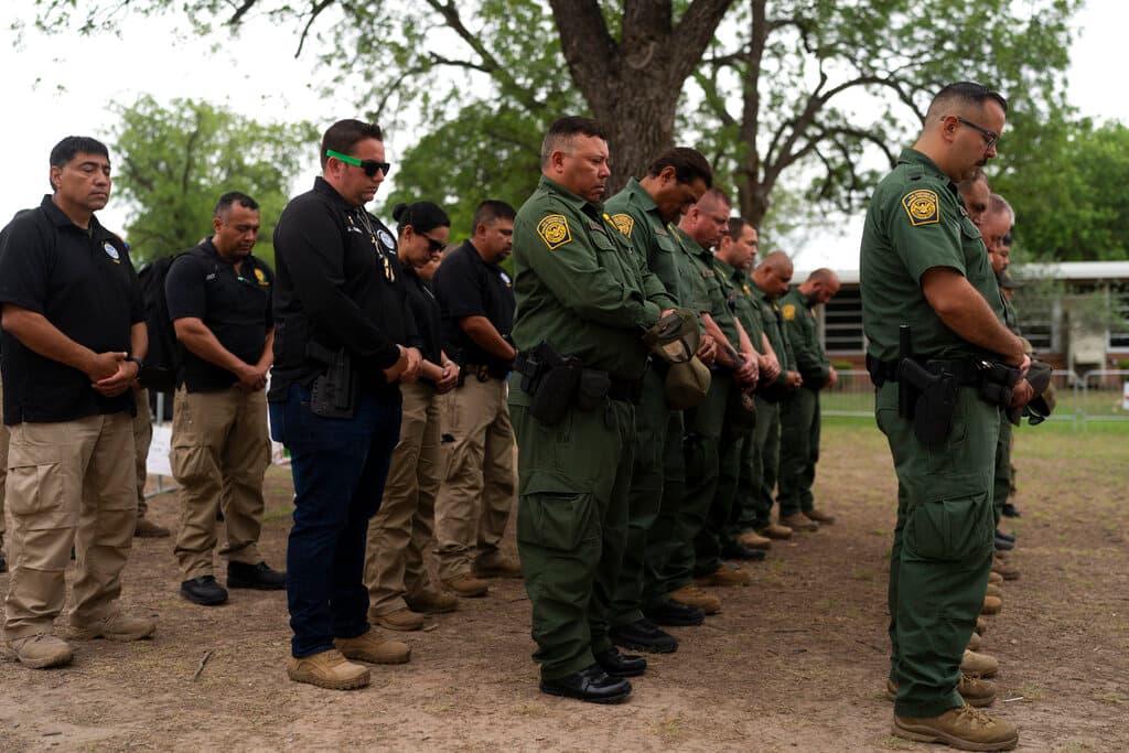 Agentes de la Patrulla fronteriza rindieron respetos a las víctimas del tiroteo en la escuela primaria Robb, ante el memorial de fotos, flores, globos y velas.