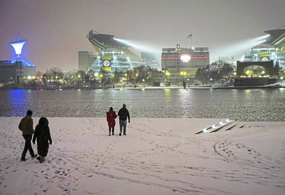 La gente camina a lo largo de la Costa Norte mientras visita el Parque Estatal Point, totalmente blanco después de la intensa nevada, en el centro de Pittsburgh.