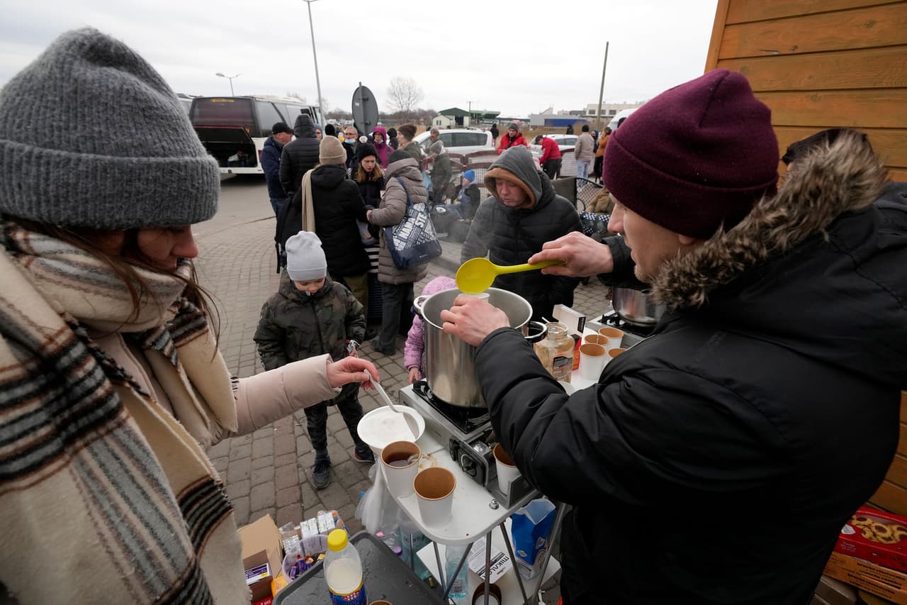 Un grupo de ucranianos reciben asistencia en el cruce fronterizo entre Ucrania y Polonia en la ciudad de Medyka. El gobierno polaco habilitó ocho centros de acogida a refugiados en su frontera con Ucrania. También puso en marcha líneas telefónicas de ayuda y publicó toda la información necesaria para las personas que están saliendo hacia Polonia en su portal.