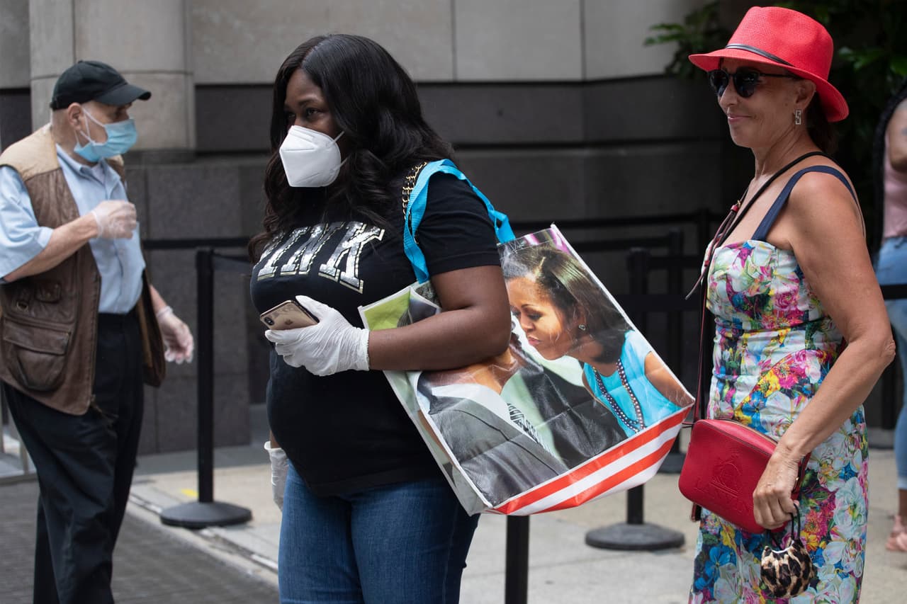 Compradores hacen fila frente a un mostrador de la tienda Saks Fifth Avenue en una acera de Nueva York el 11 de junio. Los efectos del virus no sólo deprimieron el gasto de los consumidores sino que aceleraron la transformación de los hábitos de consumo, perjudicando a las tiendas físicas y estimulando las compras en línea.