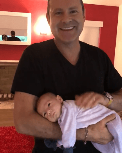 El conductor está feliz de la vida con el nuevo bebé de la casa.