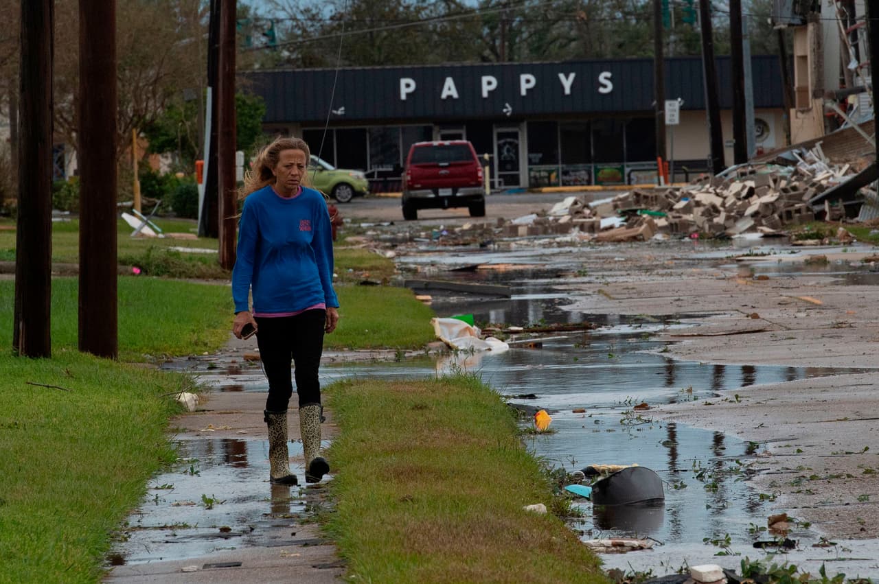 Una mujer camina en una calle llena de escombros en Lake Charles. En la parroquia de Cameron, el lugar donde impactó, las autoridades dijeron que al menos 150 personas se negaron a desalojar y tenían previsto enfrentar el huracán en sus casas.