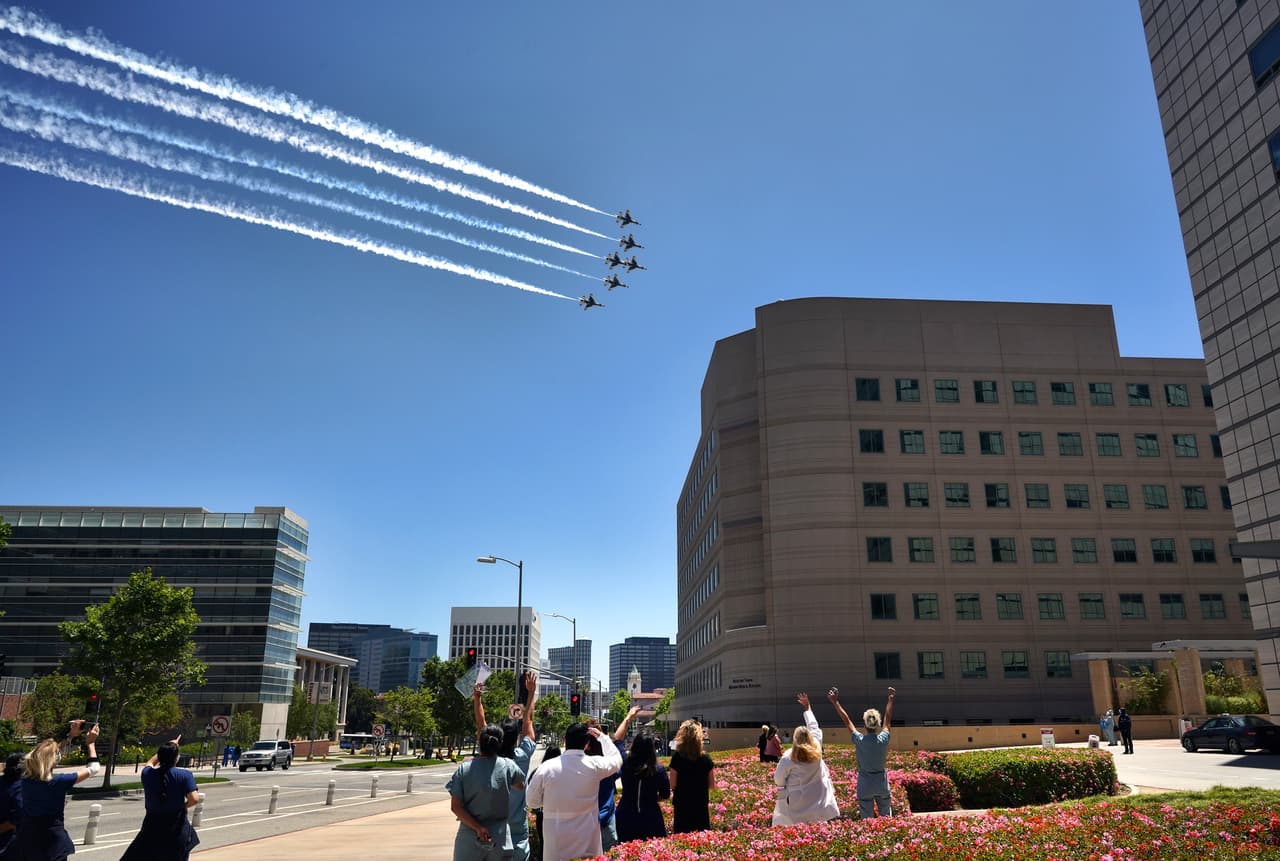 Médicos, enfermeras y otros miembros del personal en el Centro Médico Ronald Reagan UCLA observan a los Thunderbirds de la Fuerza Aérea de los EEUU volar el viernes 15 de mayo de 2020.