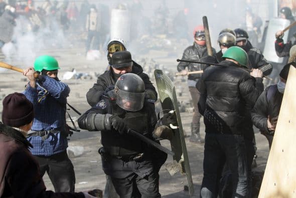 La policía ucraniana cercó hoy a los manifestantes en el corazón de las protestas opositoras de la plaza de la Independencia de Kiev (Maidán), tras una jornada en la que murieron 14 personas en los disturbios que estallaron en la capital. Víktor "Yanukóvich se ha convertido en un presidente sangriento", aseguró hoy el dirigente opositor Vitali Klitschkó en un llamamiento a los países democráticos para que intervengan en Ucrania y frenen la violenta confrontación. Según se acercaba la medianoche, los temidos Berkut, el destacamento antidisturbios, estrechaban el cerco en torno a los miles de manifestantes concentrados en el Euromaidán, bastión de las protestas desde el pasado 21 de noviembre. "Los extremistas de la oposición han cruzado la línea roja; matan a inocentes en la calles de la capital de Ucrania, vejan a mujeres, queman edificios y automóviles. Y si los disturbios continúan, nos veremos obligados a actuar con firmeza", rezaba el ultimátum del Servicio de Seguridad y el Ministerio del Interior de Ucrania. Advierten a los americanos que se queden dentro de las casas y de nuevo se sienten explosiones en la ciudad.