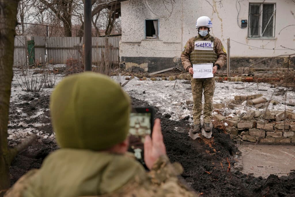 Miembros del Centro Conjunto para el Control y la Coordinación del alto el fuego de la línea de demarcación (JCCC) documentan los daños en una casa ocasionados por proyectiles de artillería que cayeron en Vrubivka este jueves, en la región de Luhansk, en el este de Ucrania.