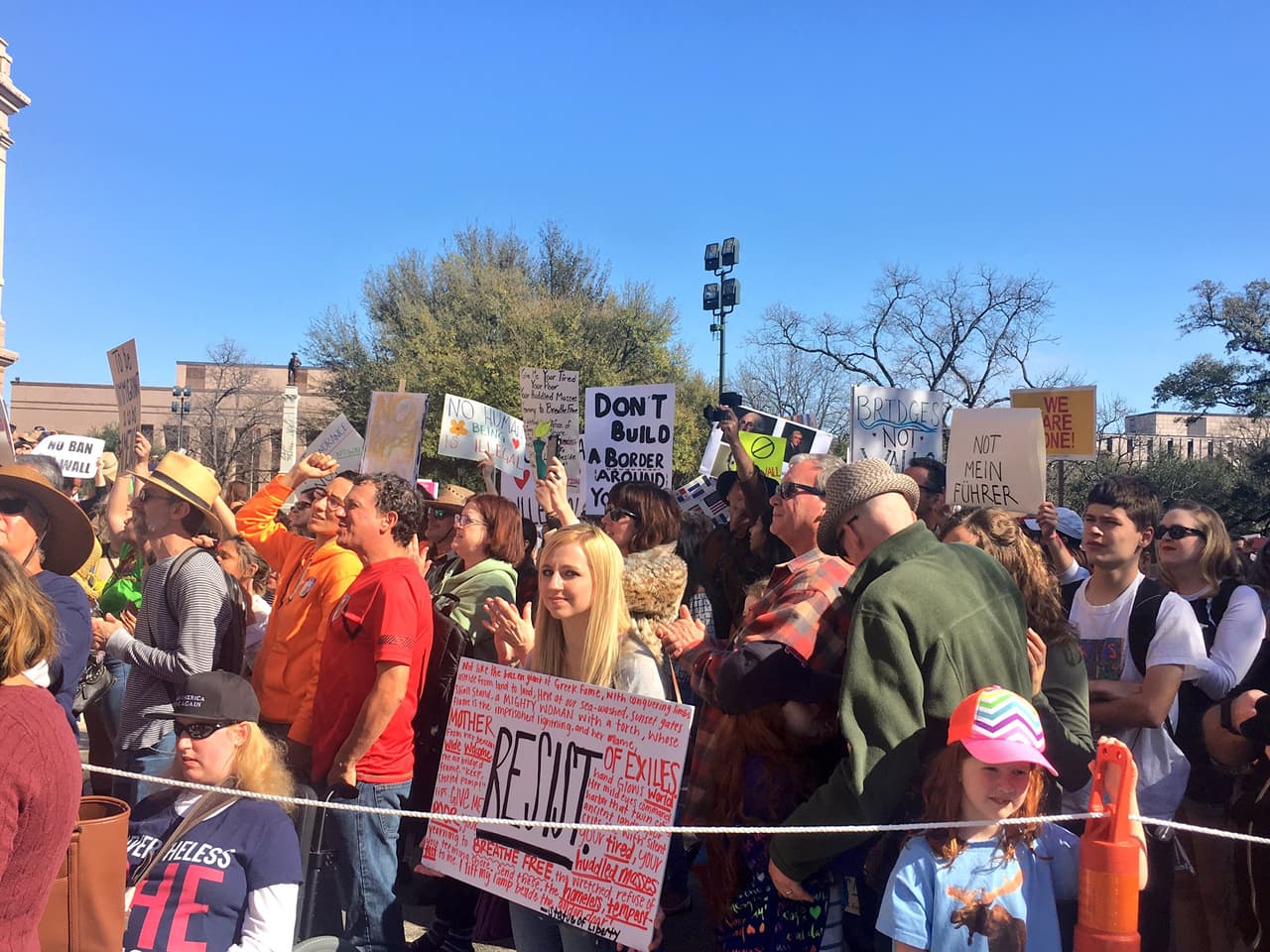 Una joven porta un cartel con la palabra “Resistencia” rodeada de otros mensajes. 
<br>