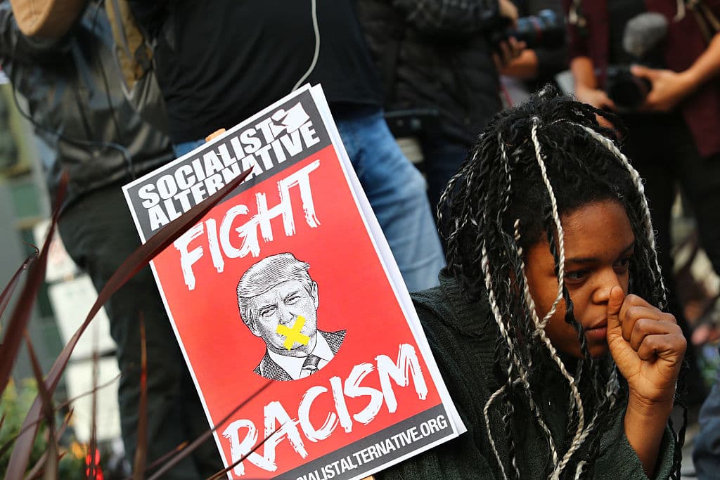 Erica Sluaghadhan, una joven afroamericana de Seattle, Washington, exige con su pancarta luchar contra el racismo en el discurso del nuevo presidente electo.