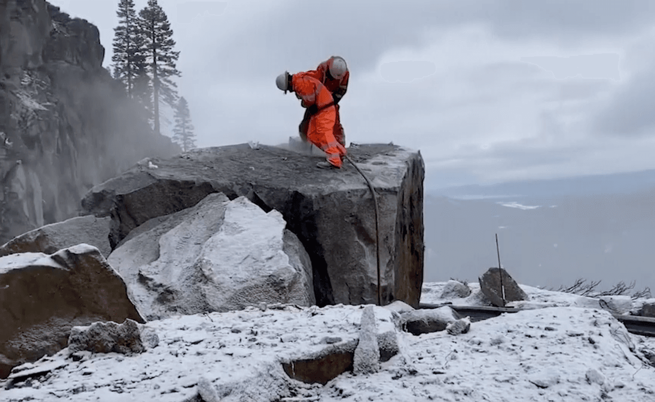 En medio de la lluvia, nevada y bajas temperaturas, los equipos de Caltrans dinamitaron las gigantescas rocas que cerraron la vía de montaña, tras derrumbe.