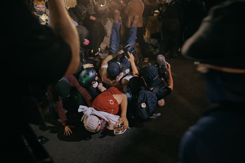 Un estallido de violencia se reportó durante la noche del miércoles, 27 de mayo, frente al centro de detención de inmigrantes Delaney Hall, en Nueva Jersey. Adentro, los detenidos están en brazos caídos desde el pasado viernes, en protesta por el trato que reciben. Afuera, familiares y amigos les ofrecen apoyo.
<br>
<br>El miércoles, se encendieron los ánimos. En medio del conflicto, agentes del Servicio de Control de Inmigración y Aduanas (ICE) defendían su perímetro empujando lo mismo a manifestantes que a periodistas, que caían unos, encima de otros, como se observa en la imagen.