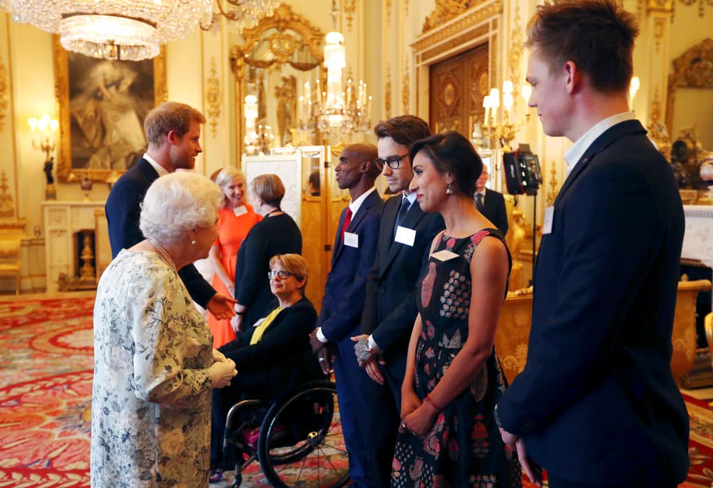 La reina Isabel II de Gran Bretaña, a la izquierda, y el príncipe Harry, segundo a la izquierda, saludan, a Mo Farah, entre otros, durante una recepción previa a la ceremonia de los Premios a los Jóvenes Líderes de la Reina en el Palacio de Buckingham, en Londres, el jueves 29 de junio de 2017.