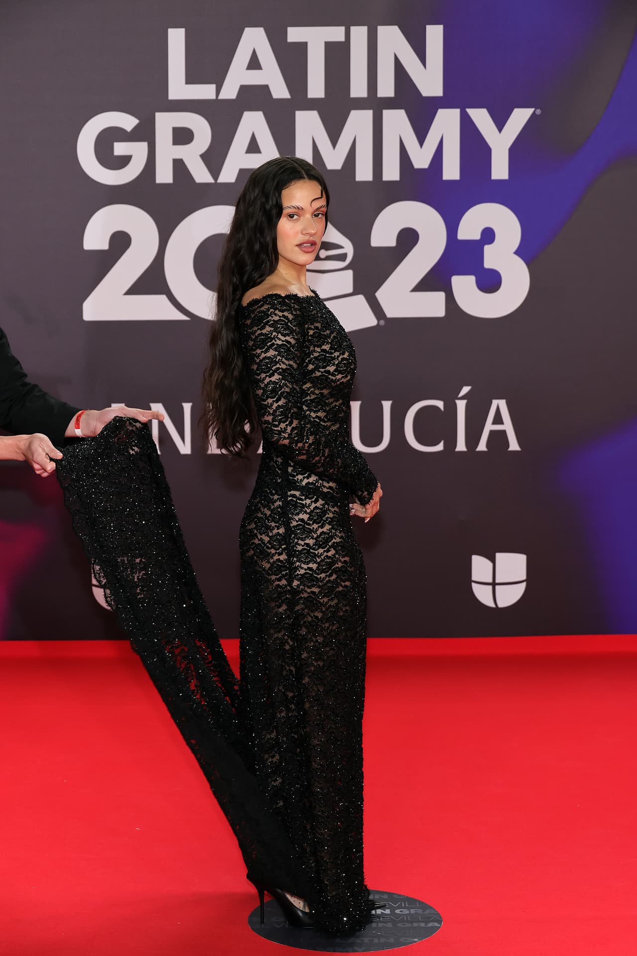 <b>Rosalía</b> apostó por un vestido ajustado y de encaje negro con una cola larga.