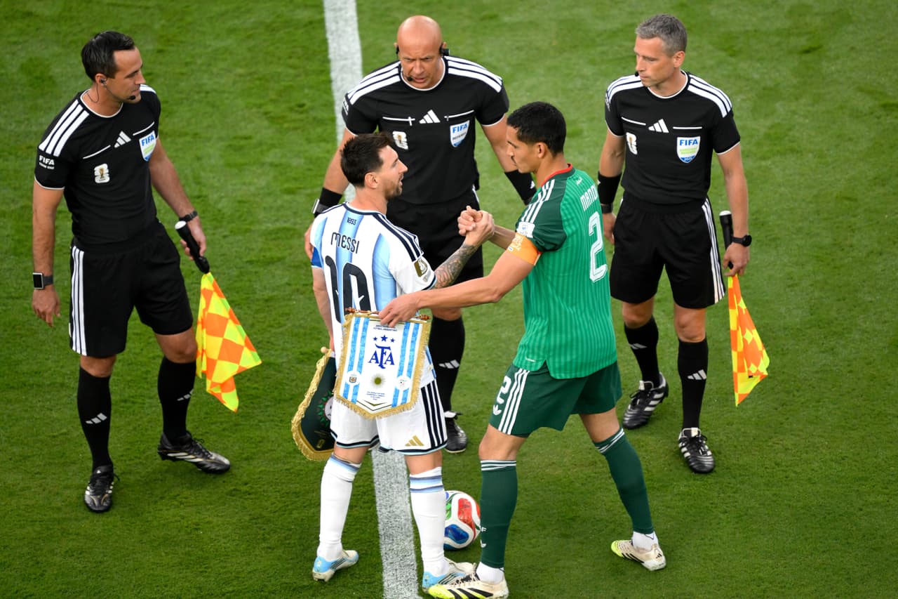 El argentino Lionel Messi (10) y el argelino Aissa Mandi (2) se estrechan la mano antes del partido de fútbol del Grupo J de la Copa del Mundo entre Argentina y Argelia en Kansas City.