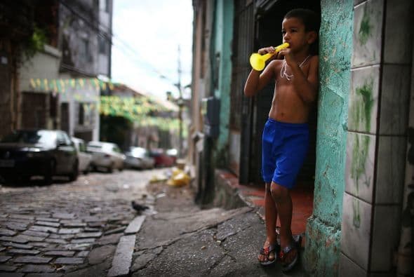 Un niño brasileño toca una trompeta en las calles de Brasil.