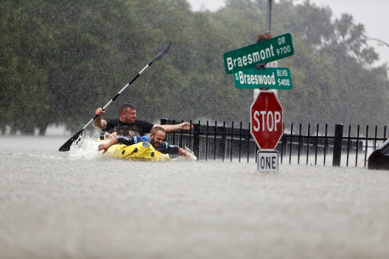 Dos kayakistas tratan de vencer a la corriente en la inundación de Houston.