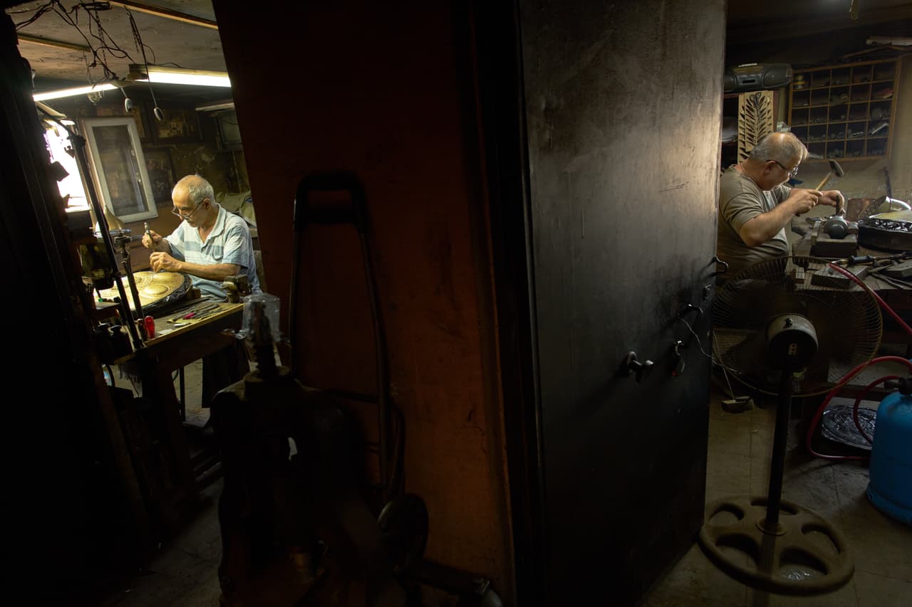 Los maestros artesanos Nejat Kilic (derecha) y Halit Cakar, especializados en trabajos de incrustación y relieve, trabajan en su taller en el distrito comercia