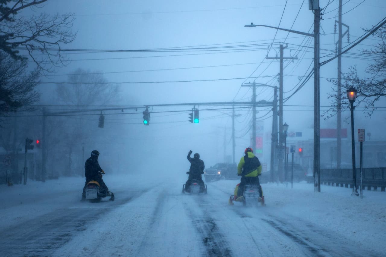 Los residentes de Medford, Nueva York, se desplazan por una calle de la ciudad en sus motos de nieve.
<br>