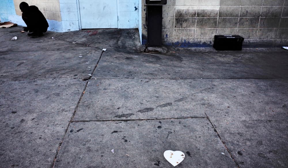 Un hombre con enfermedad mental habla consigo mismo mientras se acurruca en una acera de Skid Row. Se estima que el 40% de los indigentes padece algún tipo de trastorno mental severo o es adicto a las drogas.