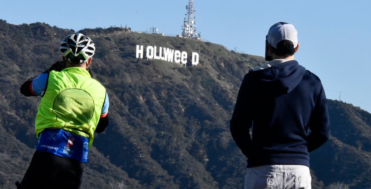 The famous Hollywood sign reads "Hollyweed" after it was vandalized, January 1, 2017. Police said unidentified thrill-seekers had climbed up and arranged tarps over the two letter "O's" to make them look like "E's," CBS affiliate KCAL reported. Each letter is 45 feet (13.7 meters) high, so the feat would have required not just bravado but considerable athleticism. / AFP / Gene Blevins (Photo credit should read GENE BLEVINS/AFP/Getty Images)