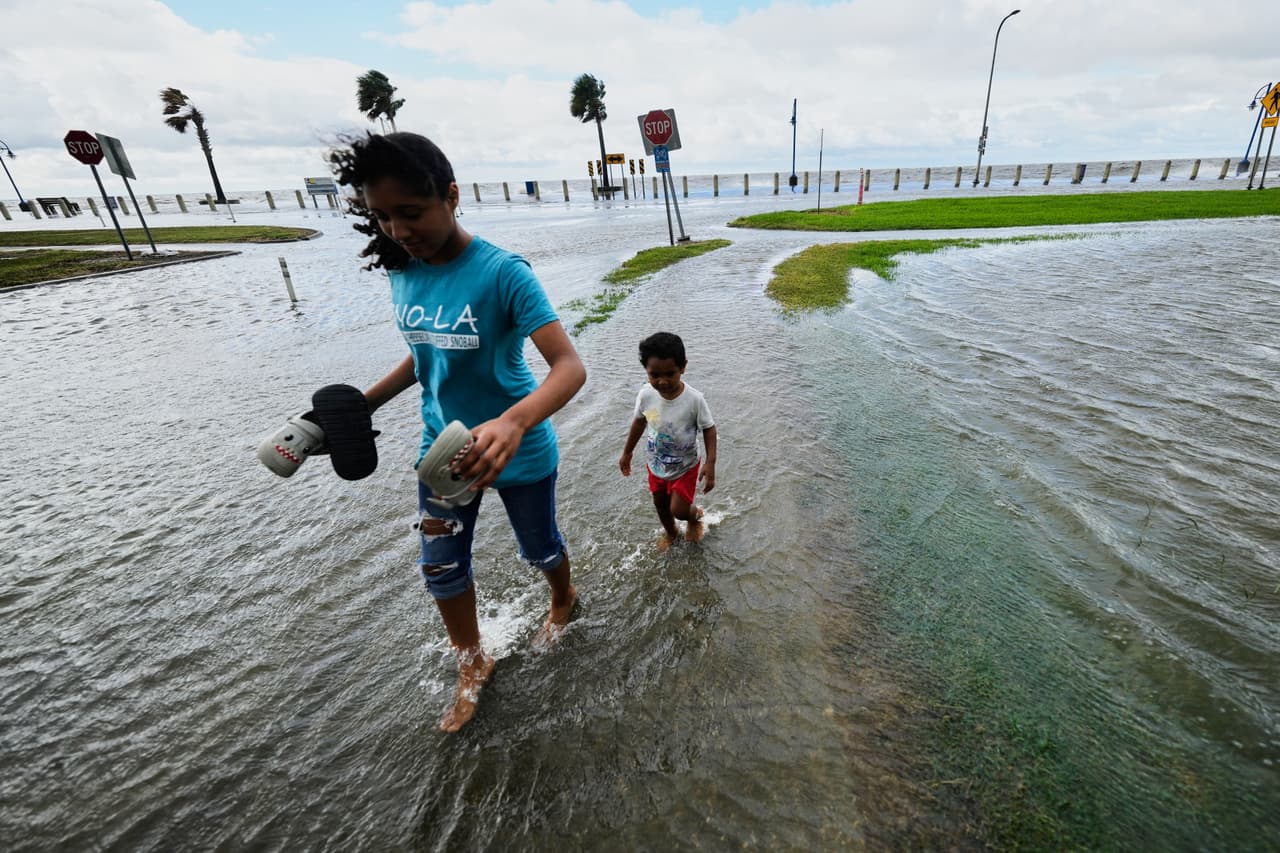 Kobe Crossley, de 3 años, y Amaya Crossley, de 12, juegan en las aguas que inundan Lakeshore Drive, junto al lago Pontchartrain, mientras la tormenta tropical Bertha se acerca a la costa de Luisiana el miércoles 22 de julio de 2026, en Nueva Orleans. (Foto AP/Gerald Herbert)