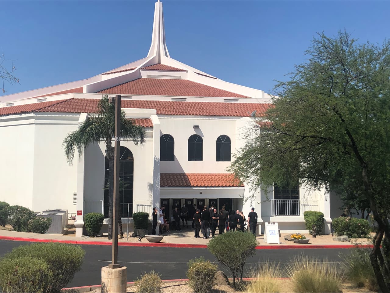 En la parte de atrás de la iglesia el grupo organizador, vestidos de negro, se preparan para recibir a los asistentes.