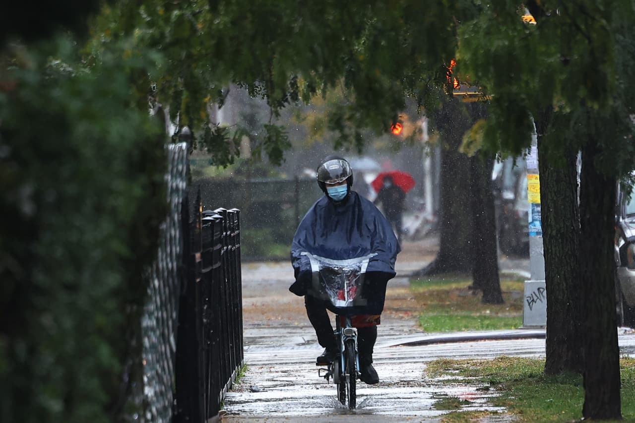 Un trabajador de entregas conduce su bicicleta bajo la lluvia en Nueva York.