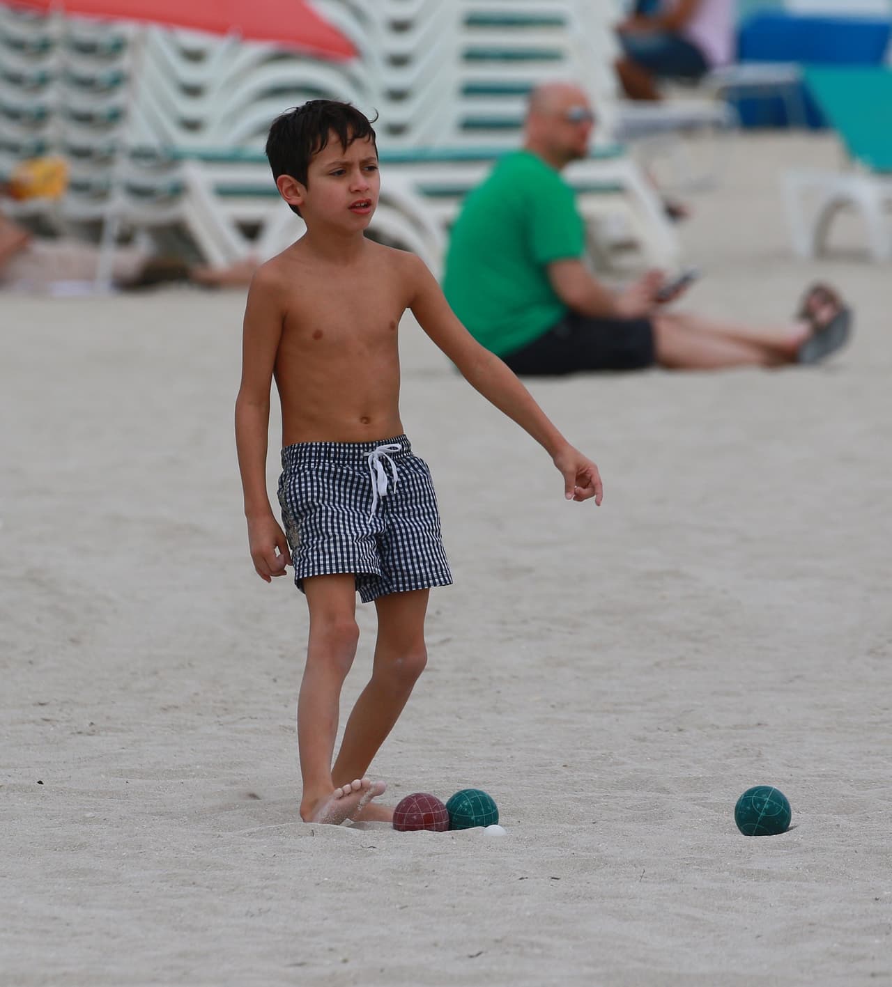 El pequeño Max con sus juguetes en la arena.
