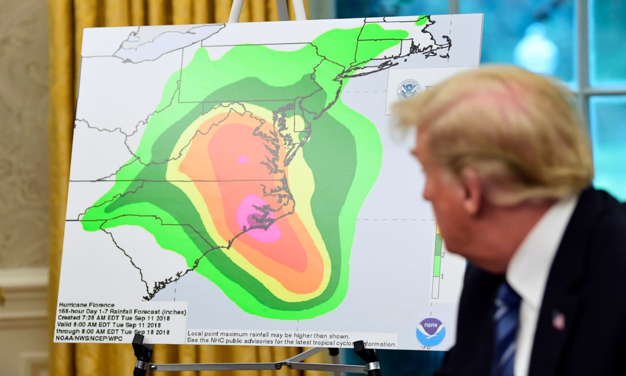 President Donald Trump looks at a chart showing potential rainfall totals from Hurricane Florence during a briefing in the Oval Office of the White House in Washington, Tuesday, Sept. 11, 2018. (AP Photo/Susan Walsh)