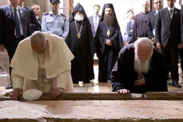 El papa Francisco y el patriarca ecuménico de Constantinopla, Bartolomé I oran por la Piedra de la Unción en la Iglesia del Santo Sepulcro de Jerusalén.