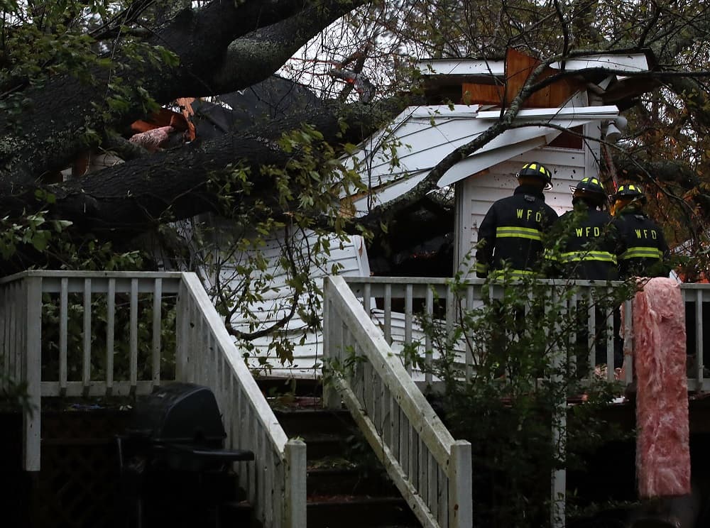 WILMINGTON, NC - SEPTEMBER 14: Firefighters arrive at a home where a large tree fell on that had three people trapped, after Hurricane Florence hit the area, on September 14, 2018 in Wilmington, North Carolina. One man was taken out of the home in critical condition, and the condition of two others is unknown. Hurricane Florence hit Wilmington as a category 1 storm causing widespread damage and flooding along the Carolina coastline. (Photo by Mark Wilson/Getty Images)
