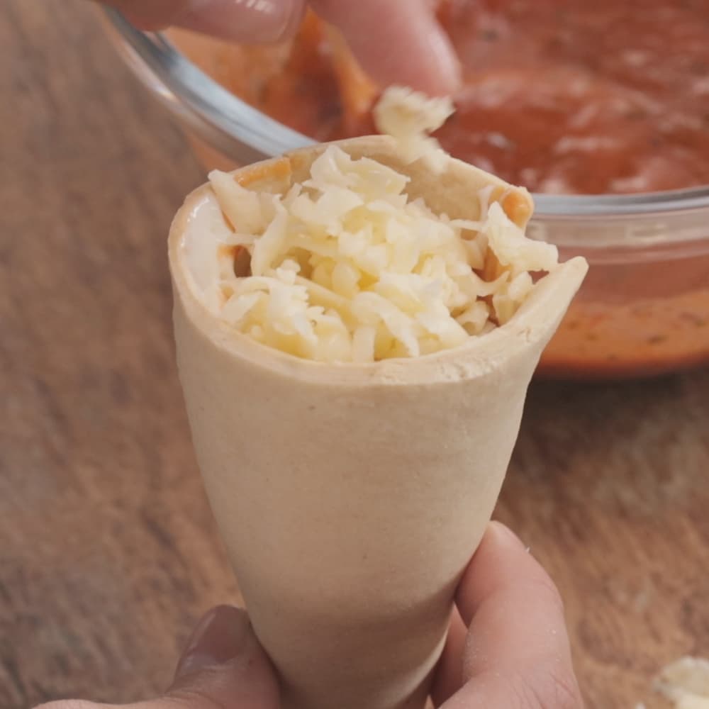 Preparación de un cono de pizza con mozzarella