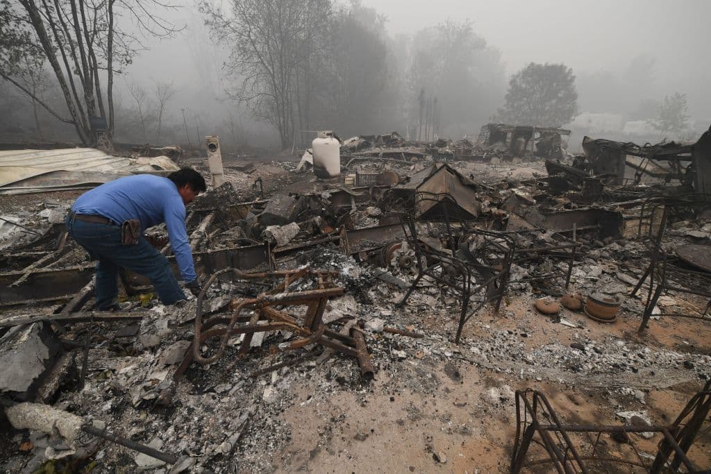 Marcelino Maceda busca en los restos de su casa móvil luego de que un incendio arrasara el parque en el que vivía destruyendo varias casas en Estacada, Oregon.