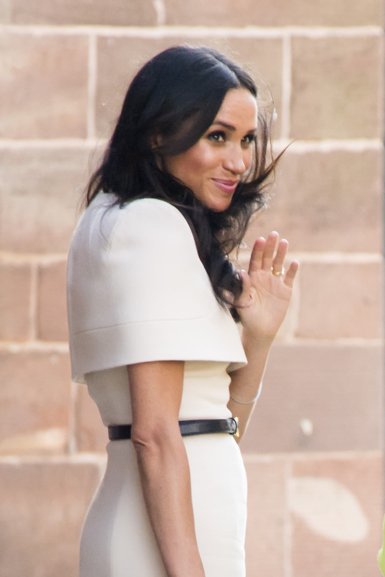 Así fue para el viaje con la reina en tren, la duquesa usó un vestido recto de Givenchy que
<a href="https://www.univision.com/entretenimiento/leccion-aprendida-meghan-markle-se-tapa-los-hombros-para-su-evento-oficial-al-lado-de-la-reina-isabel-ii">contaba con una capa</a> que cubría hasta arriba del codo.