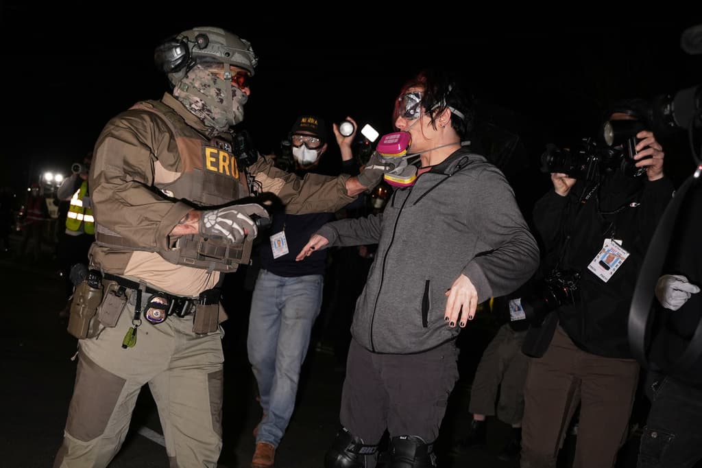 Un agente federal de inmigración le quita la mascarilla respiratoria a un manifestante a las afueras del centro de detención Delaney Hall el jueves 28 de mayo de 2026 en Newark, Nueva Jersey. (Foto AP/Angelina Katsanis)