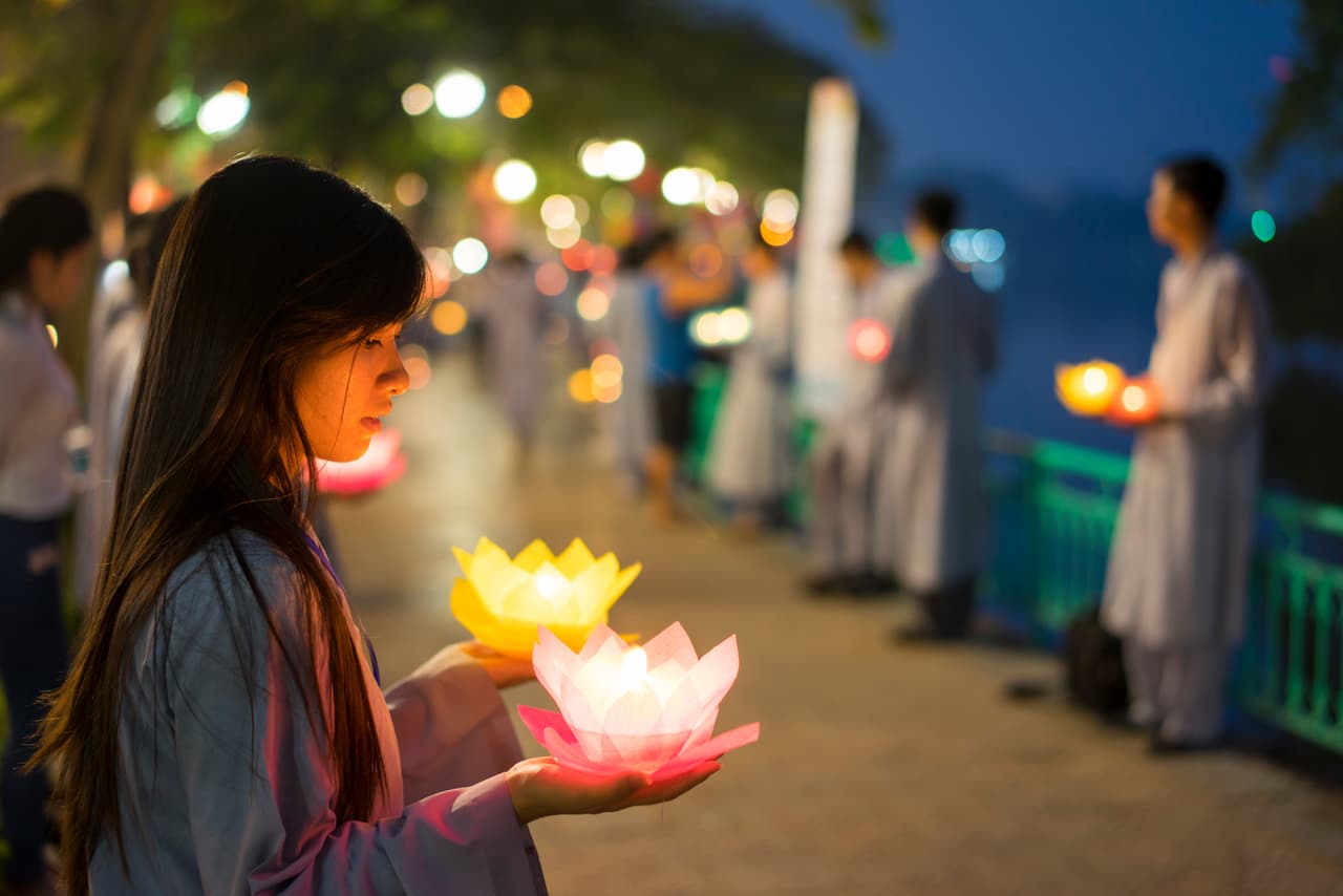 Hanoi, Vietnam - Oct 10, 2014: Buddhists hold flower garlands and colored lanterns for celebrating Buddha's birthday organised at Tran Quoc temple