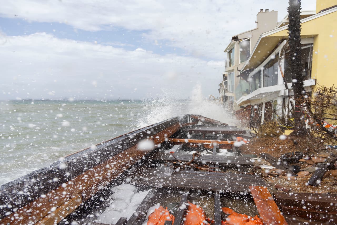 Las olas rompen contra las casas y el paseo marítimo dañados por la tormenta tropical Rachel en la península de Alamitos, el domingo 11 de octubre de 2026, en Long Beach, California.