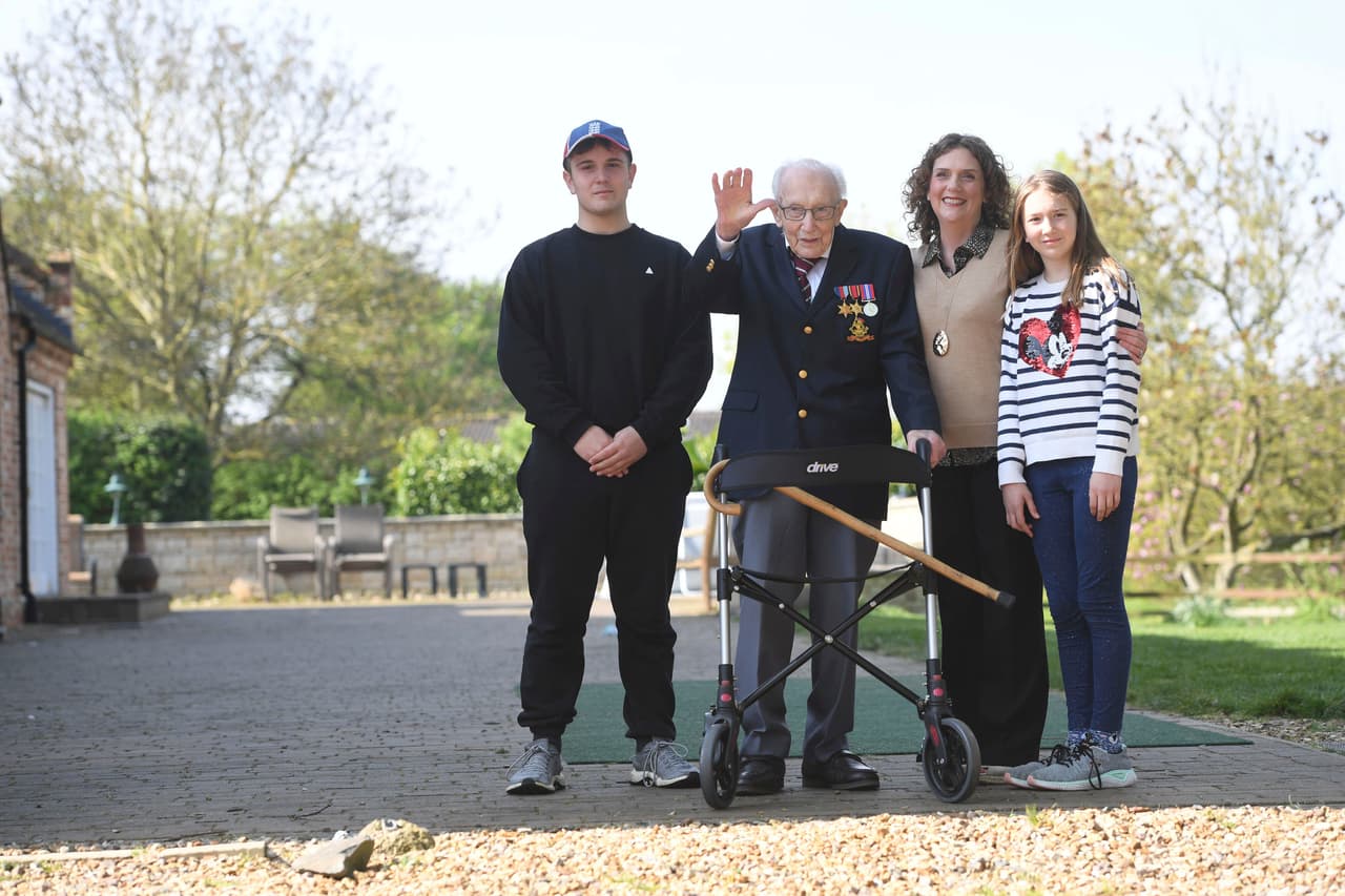 Moore y parte de su familia en el jardín de su residencia en Marston Moretaine, Reino Unido, tras darle 100 vueltas en andadera.