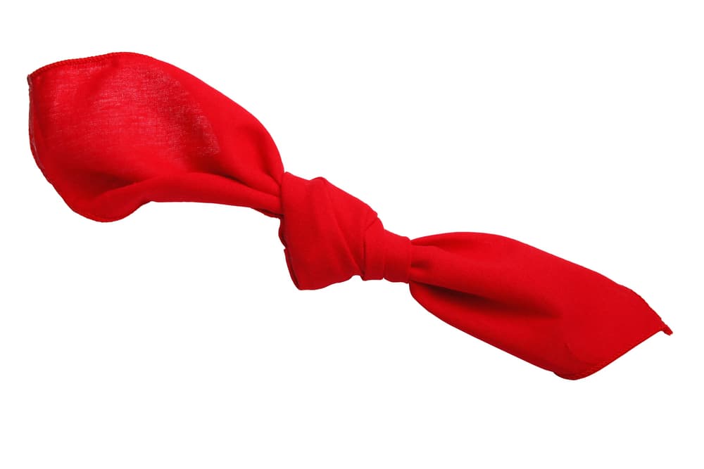 Concentrándote en la foto y su amor, ve haciendo siete nudos en el listón rojo, de esta manera.