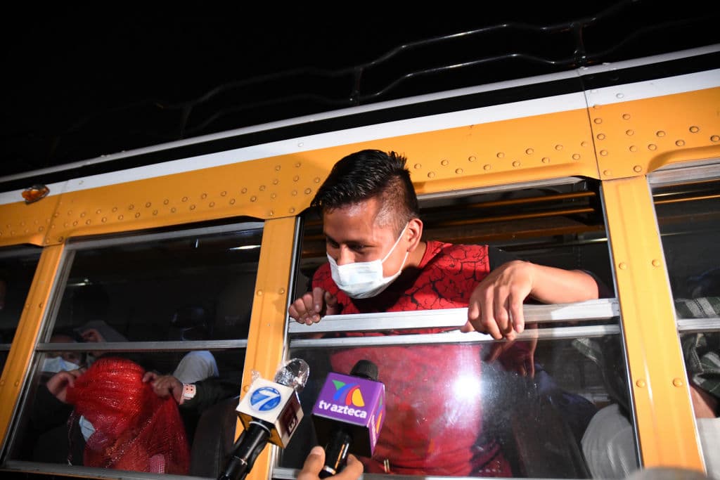 A migrant, part of a group of 71 Guatemalans deported from the United States, wears a face mask as a preventive measure against the novel coronavirus COVID-19, as he speaks with journalists from a bus, after landing at the Air Force base in Guatemala City on May 11, 2020. - Guatemalan immigration authorities confirmed on Monday that in the last two months it received 102 deported migrants infected with the novel coronavirus, COVID-19, from the United States. (Photo by Johan ORDONEZ / AFP) (Photo by JOHAN ORDONEZ/AFP via Getty Images)