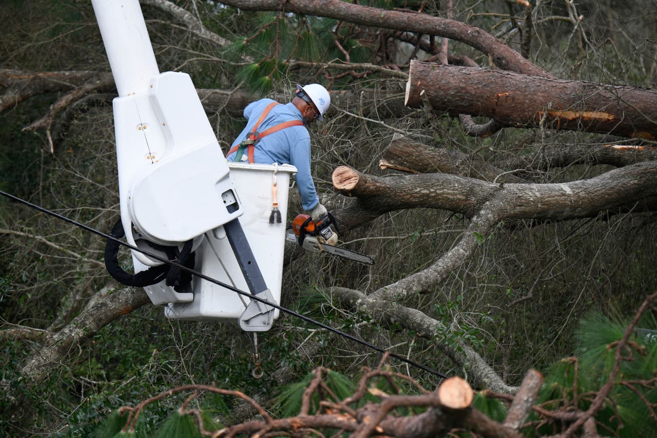 El trabajador de Florida Power & Light, Yosvany Quintero, retira las ramas de árboles caídas a causa de los efectos del huracán Isaias el sábado 10 de octubre de 2026 en East Milton, Florida