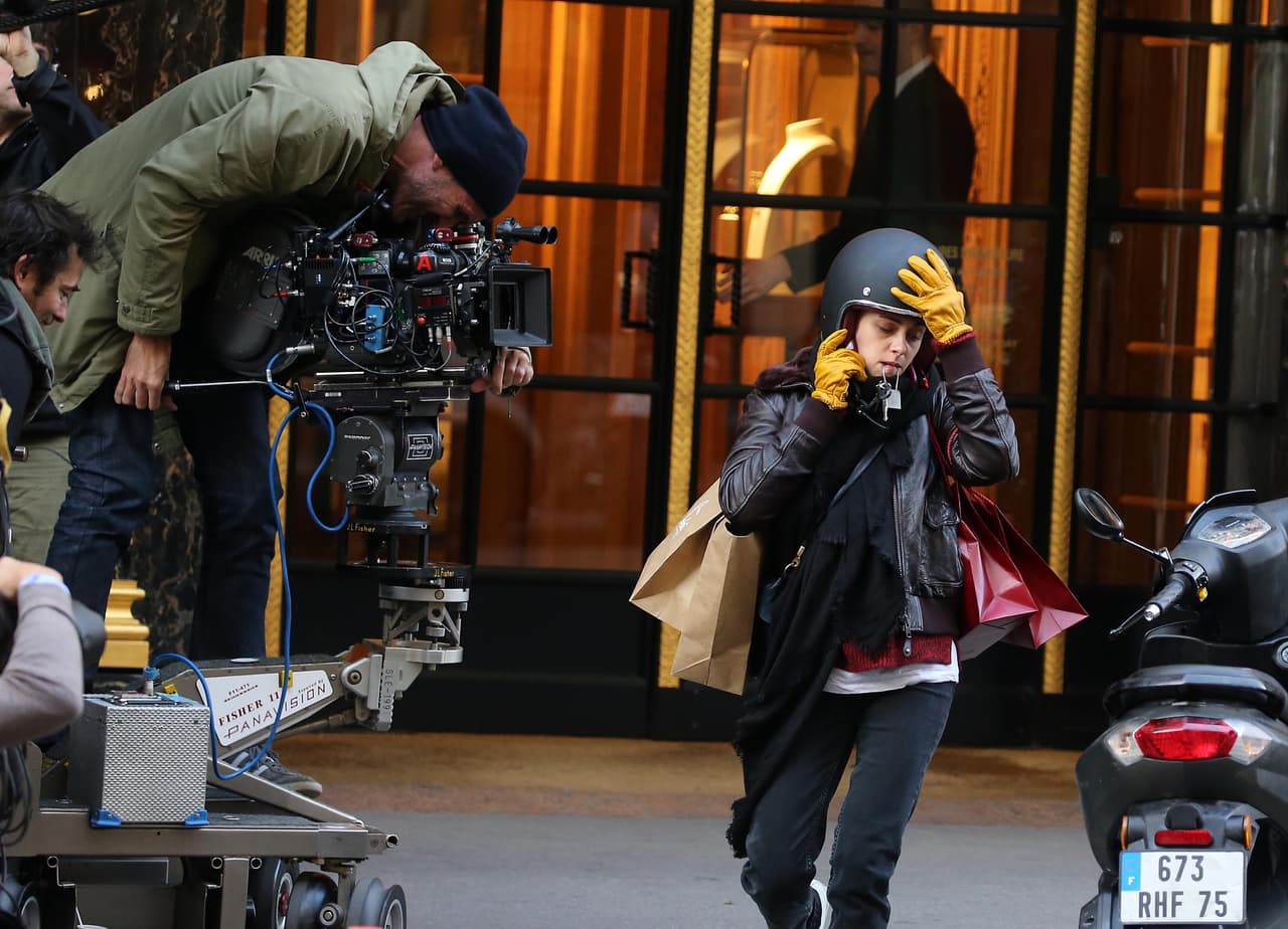 Al teléfono y poniéndose el casco.